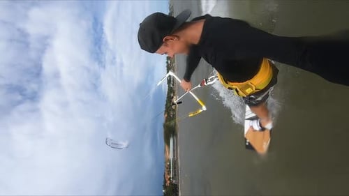Caucasian man holding GoPro while kite surfing on ocean. Vertical video