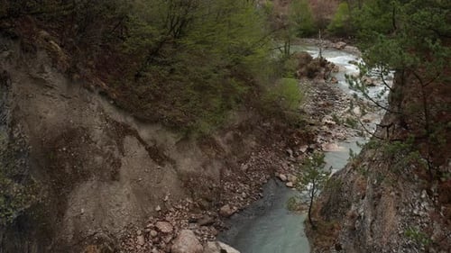 Panoramic View of Mountain River Flowing through Steep Forested Hillside