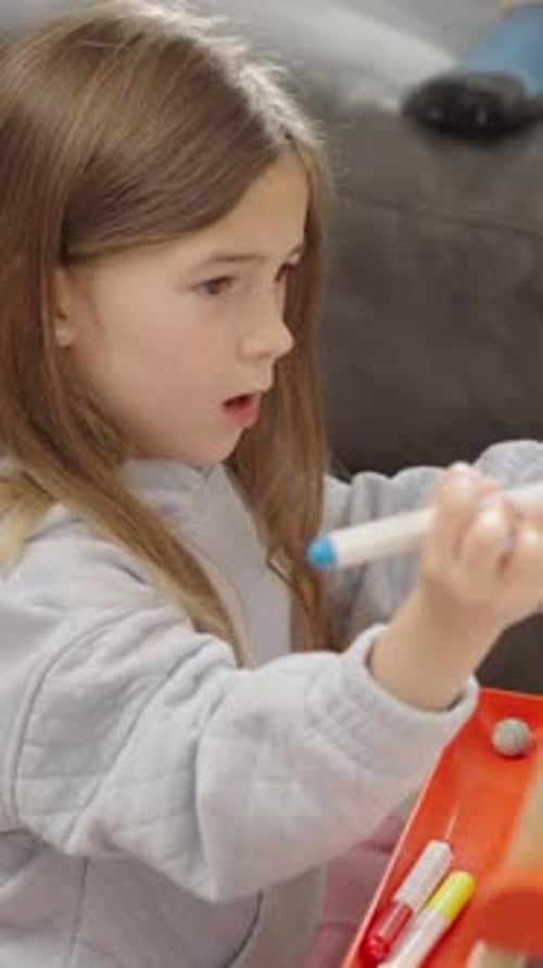 Girl Drawing on Whiteboard with Markers Indoors