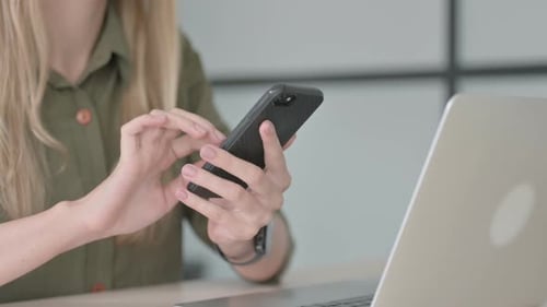 Nahaufnahme einer blonden Frau mit dem Smartphone