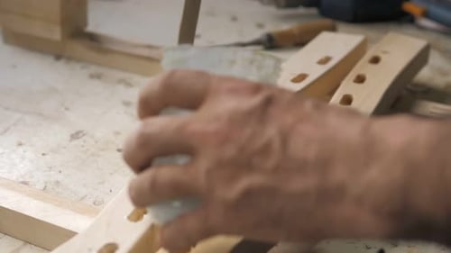 A Carpenter in the Workshop Lubricates Furniture Parts with Glue in the Workshop
