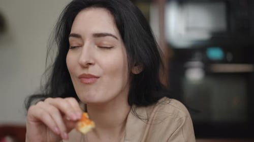 Dark Haired Woman Enjoys Food Indoors