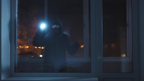 Dark Figure with Flashlight Opening Window at Night