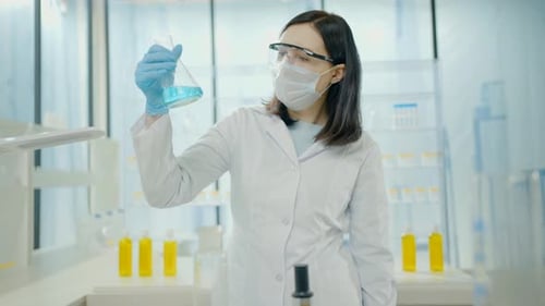 Woman Scientist Examines Blue Liquid in Laboratory