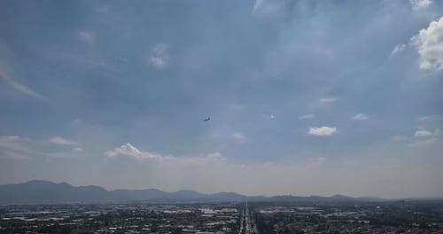 Descending Drone Tracking Shot of Airplane Approaching Airport in Mexico City at Midday