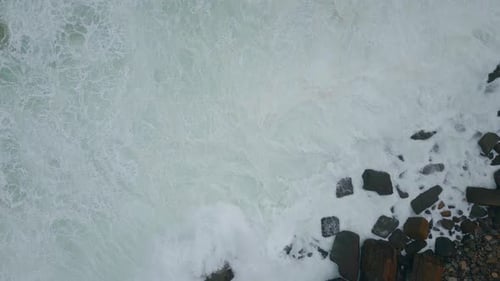 Ocean Froth Washing Rocks Drone Shot Stormy Waves Crashing of Rough Terrain