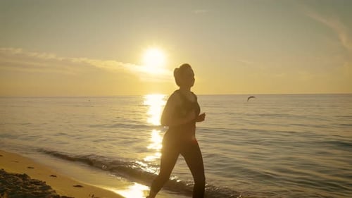 Adult Woman Exercising with Outdoor Running at Sunset Sea Beach