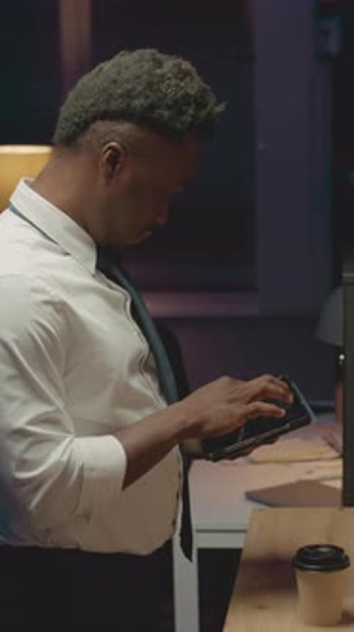 Man Uses Cellphone Inside Dark Office Environment