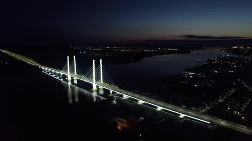 Illuminated Industrial Bridge Traffic Transportation Over River Sea at Night Aerial Panorama View