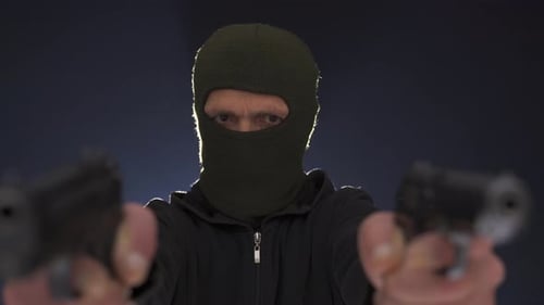 Shooter man is looking for enemies by aiming his two guns, he is committing robbery.