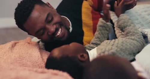 Happy Father Smiling at Baby on Bed
