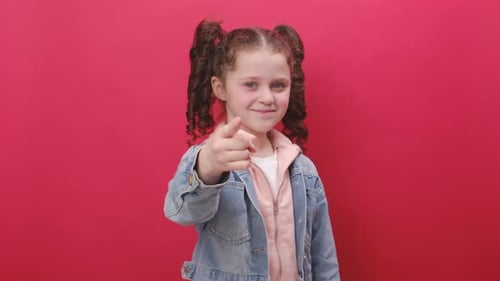 Portrait of little girl kid smiling excitedly and pointing finger to camera, choosing lucky winner