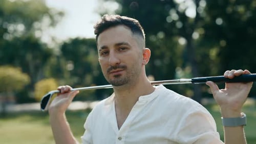 Attractive Golf Player Looking at Camera in Sunny Park