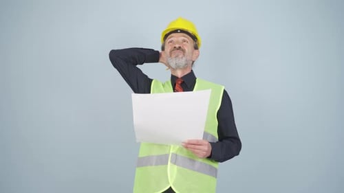 Looking up, the engineer is holding his hard hat.