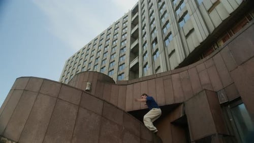Man performs parkour on an urban building