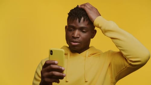 Young Adult Using Phone Shows Confusion