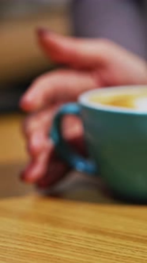 Cup of coffee on wooden table. Barista selling coffee to consumer in cafe