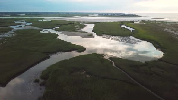 High altitude drone wide-view flyover of mason inlet marsh and beach ...