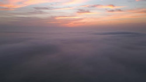 Aerial View of a Sunrise Sea with a Blanket of Morning Fog and Morning Sunbeams Shining Through