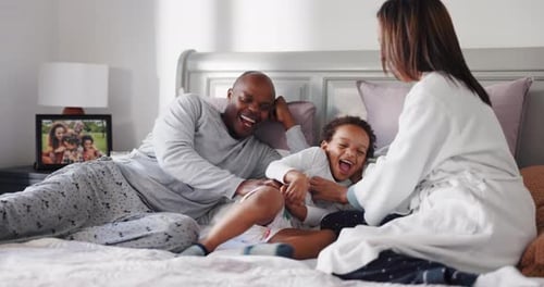 Playful Family Laughter in Cozy Bedtime Scene