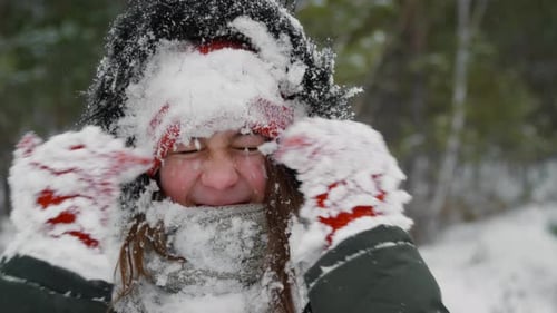 Happy Girl Covered in Snow in Winter Forest