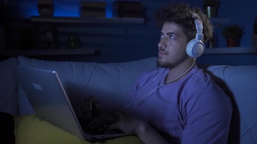 Man Relaxes at Night Using Laptop