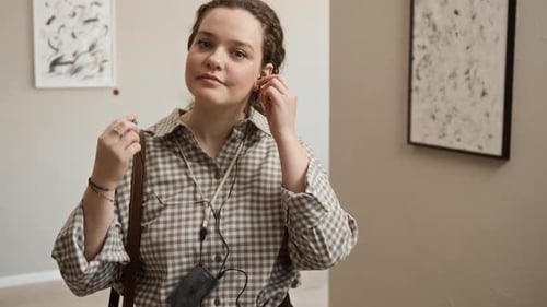 Porträt einer jungen Frau, die in der Kunstgalerie die Kopfhörer des Audioguides auszieht