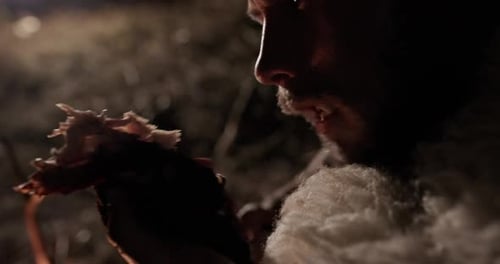Primitive Man Eating Meat Near Fire