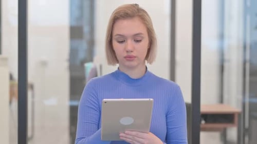 Young Woman Using Tablet in Modern Office
