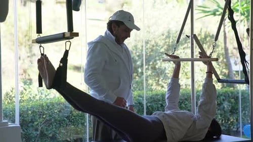 A Trainer Helps a Girl Do an Exercise in the Gym