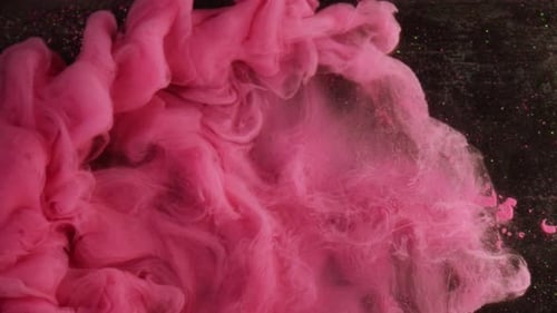 Pink Ink Swirling Abstractly on Dark Background