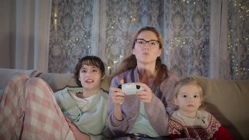 Family Playing Video Games on Couch at Night