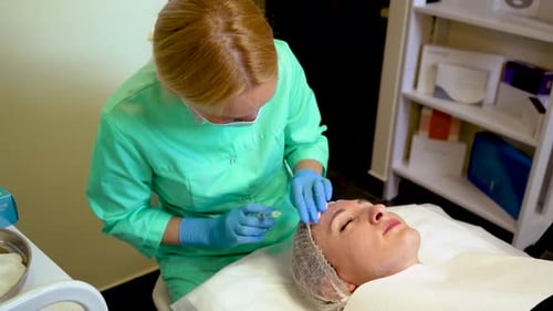 Woman Receiving Injection in Forehead in Medical Office