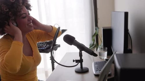 African singer recording song at music production home studio - Audio engineer woman mixing album