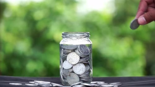 Coins Added to Jar with Savings