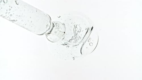 Dropper Dispenses Serum with Bubbles on White