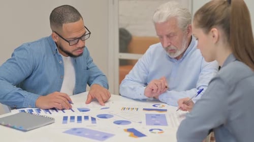 Business Team Analyzes Data in Bright Office