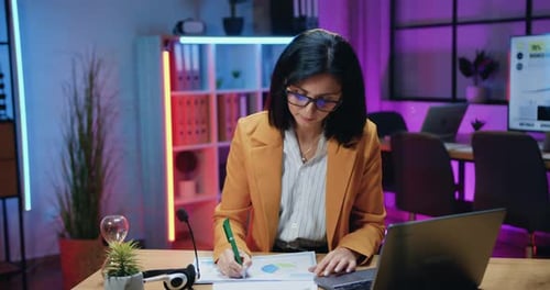 Woman Analyzes Data in Modern Office