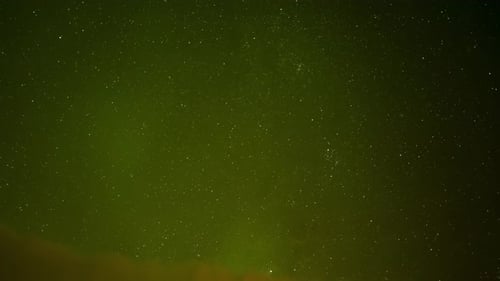 Beautiful Aurora Borealis shining in a starry night sky with falling meteoroids. Slowly panning over