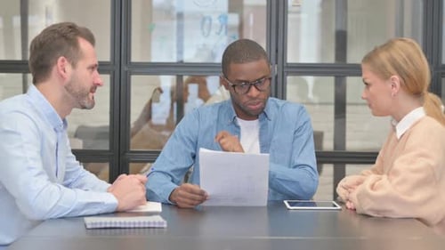 Business Meeting with Diverse Team Discussing Documents