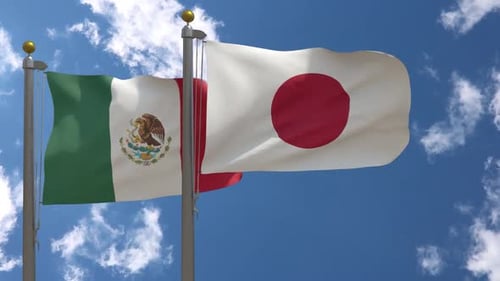 Waving Flags of Mexico and Japan on Flagpoles Against Blue Sky