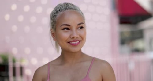 Smiling woman with blonde hair stands outside