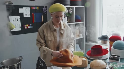 Woman Shapes Hat with Steam in Millinery Workshop
