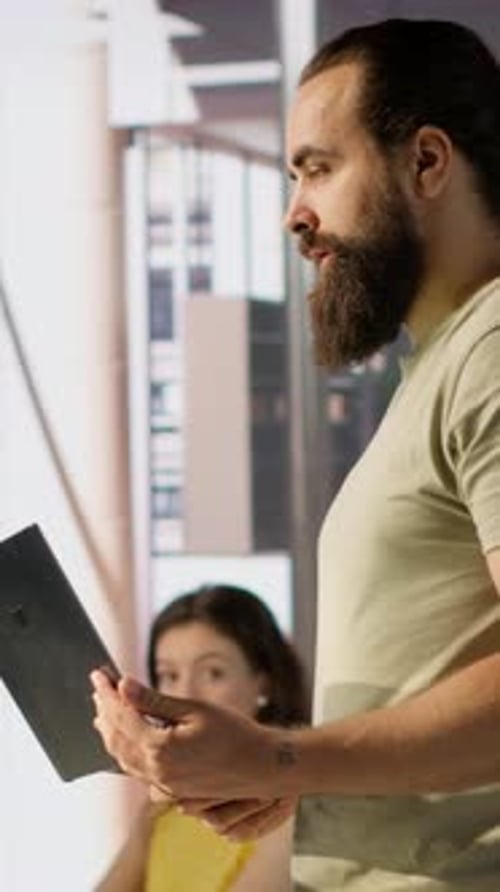Man Discussing Tablet with Coworkers in Modern Office