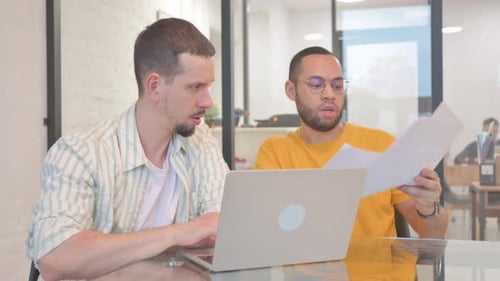 Men Collaborating on a Laptop in Office Setting