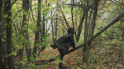 Individual Navigating Autumn Woods Wearing Layered Clothing and Smiling Woman in Leather Jacket