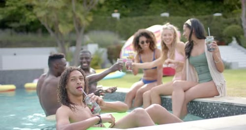 Diverse young adults enjoy a pool party outdoors