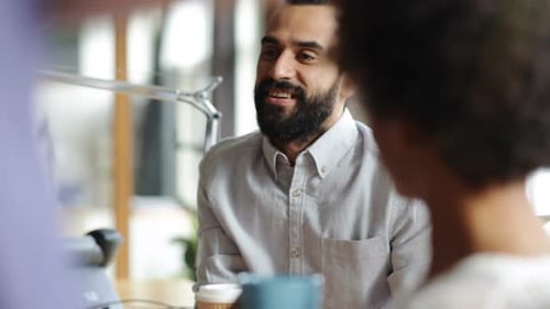 Creative business team enjoying coffee break conversation in modern office