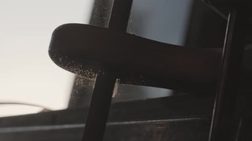 Closeup of a Carpenter Working on a Wooden Cutting Board Hole with a File in His Workshop