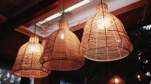 Decorative wicker lamps hanging indoors with warm light with a cozy and stylish interior atmosphere